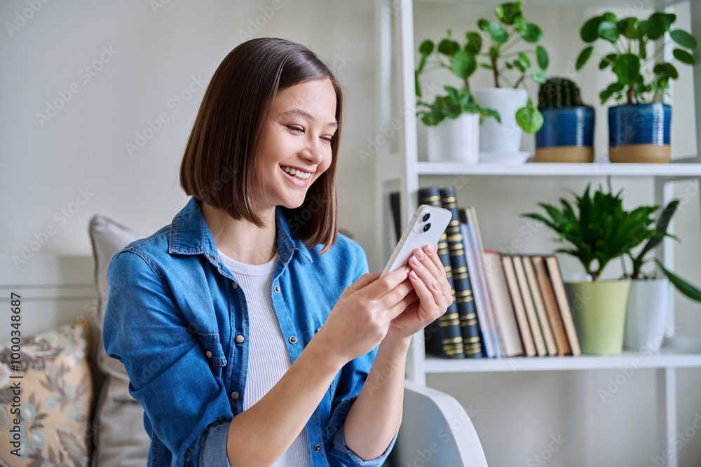 Young woman using smartphone sitting on couch at home Young woman using smartphone sitting on couch at home