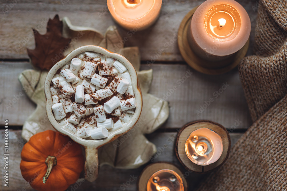 Flat lay top view. Spicy sweet fall hot drink: delicious pumpkin latte with cinnamon, marshmallow. Served in handmade artisan mug in shape of pumpkins, cozy home decor with candles, dry autumn leaves Flat lay top view. Spicy sweet fall hot drink: delicious pumpkin latte with cinnamon, marshmallow. Served in handmade artisan mug in shape of pumpkins, cozy home decor with candles, dry autumn leaves