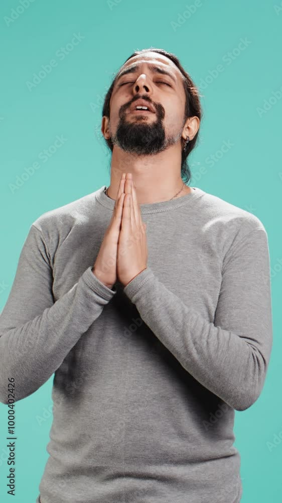 Vertical video Pious man praying to his god, asking for forgiveness. Spiritual person doing worship hand gesturing, confessing, begging for pardon, isolated over studio background, camera B Vertical video Pious man praying to his god, asking for forgiveness. Spiritual person doing worship hand gesturing, confessing, begging for pardon, isolated over studio background, camera B