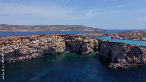 Aerial view of the sea caves of Cominotto uninhabited island near Comino, Maltese islands. Seagull flying in the frame. High quality photo