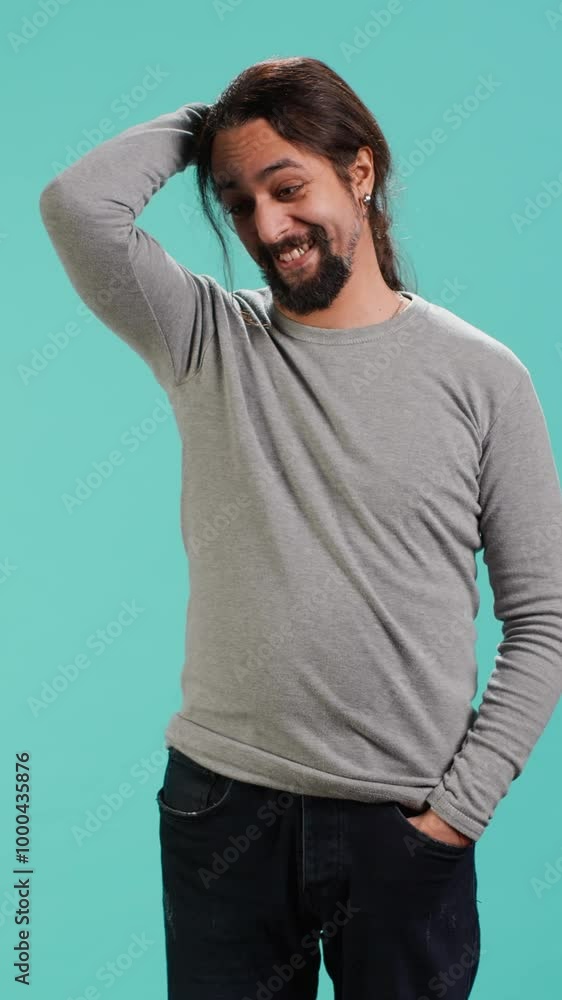Vertical video Portrait of shy man putting hand on head, feeling ashamed, isolated over studio shot. Self conscious person feeling insecure while seeing crush, feeling need to express emotions, camera Vertical video Portrait of shy man putting hand on head, feeling ashamed, isolated over studio shot. Self conscious person feeling insecure while seeing crush, feeling need to express emotions, camera