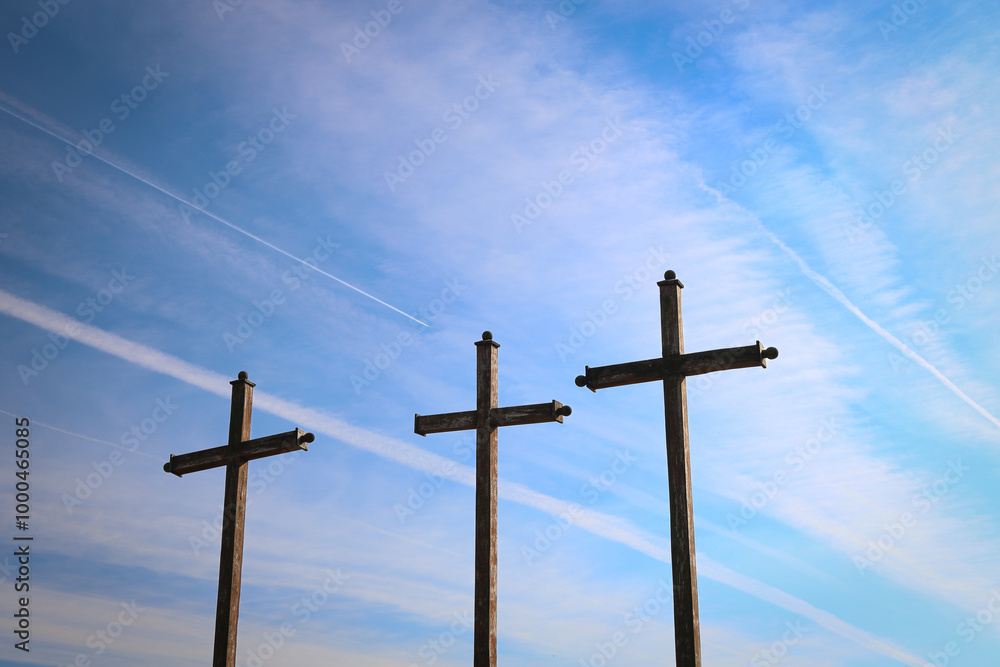 Three wooden crosses under a blue sky with contrails, symbolizing faith, hope, and Christianity Three wooden crosses under a blue sky with contrails, symbolizing faith, hope, and Christianity