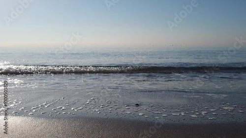 Small foamy waves on sandy beach video footage