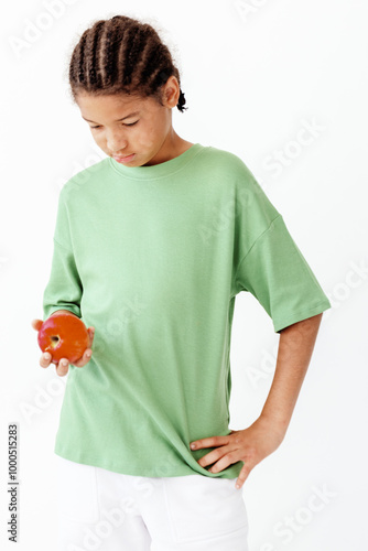 Curious boy in green shirt carefully holding a delicate goldfish in his hand outdoors photo