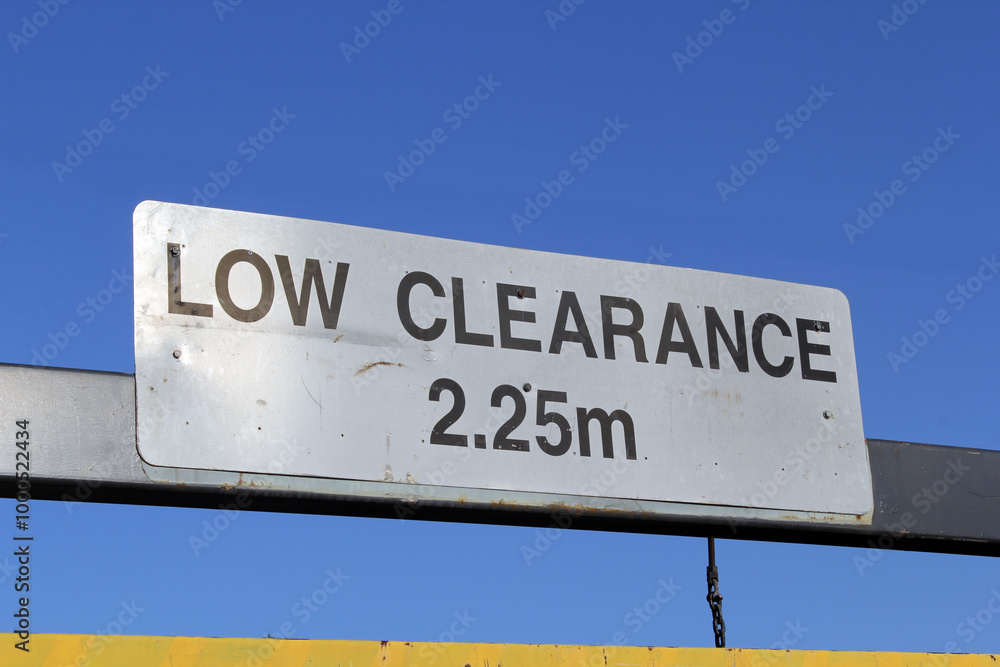 Obraz premium Low Clearance 2.25m height restriction sign against a blue sky background