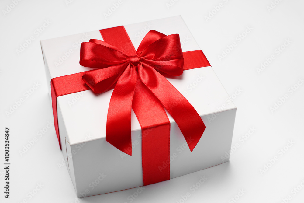 Obraz premium Gift box with red bow on light grey background