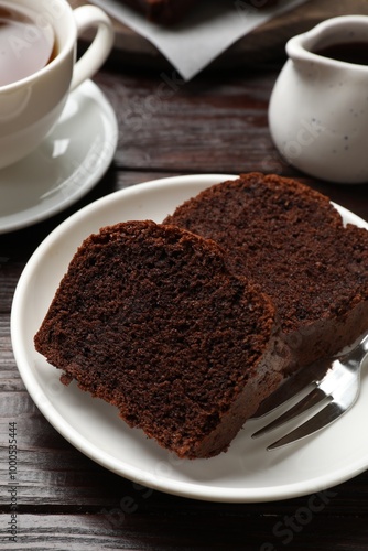 Slices of delicious chocolate sponge cake on wooden table, closeup