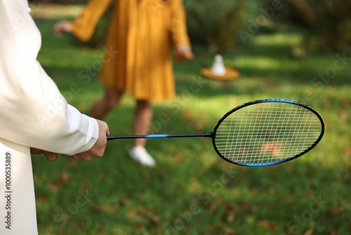 Young man and woman playing badminton in park, closeup