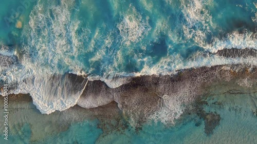 Waves crashing over the red rocks with a vibrant blue ocean in Esperance, Australia 