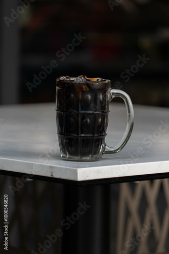 Vertical Shot of Oliang: Refreshing Thai Ice Black Coffee on a White Table – Bold Flavor and Aroma photo