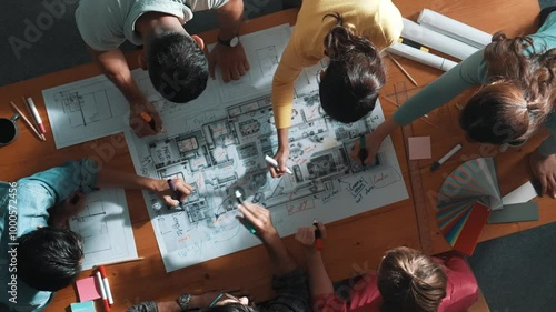 Top down view of civil engineer team writing at blueprint at meeting table with color palettes. Group of diverse people planning and taking a note while manager looking at project plans. Symposium. photo