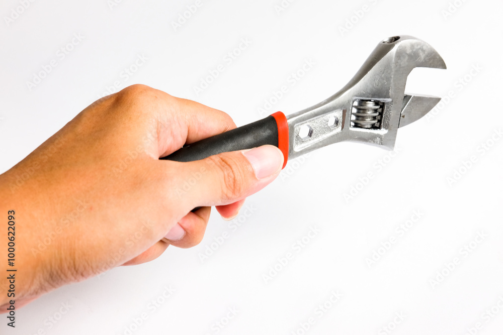 Partial view of man holding a adjustable Monkey Wrench or spanner with a handle covered in black. Hand tool designed for efficient tightening and loosening tasks. Isolated on white background Partial view of man holding a adjustable Monkey Wrench or spanner with a handle covered in black. Hand tool designed for efficient tightening and loosening tasks. Isolated on white background
