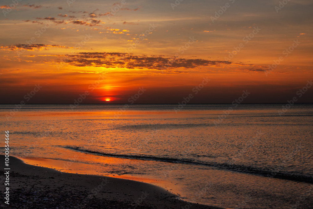 Sandy beach with pebbles of Baltic Sea on Curonian Spit at sunset. Kaliningrad region. Russia