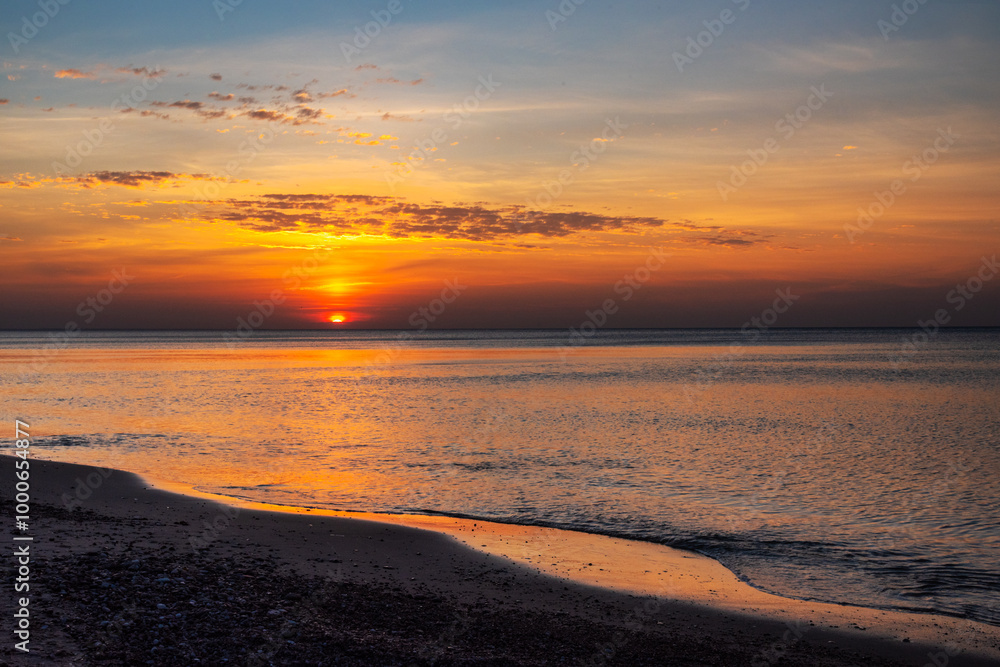 Sandy beach with pebbles of Baltic Sea on Curonian Spit at sunset. Kaliningrad region. Russia