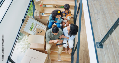 Parents, children and boxes on stairs in new home with tablet for property design and interior decoration research. Top view, family or digital app in dream house with renovation inspiration or ideas photo