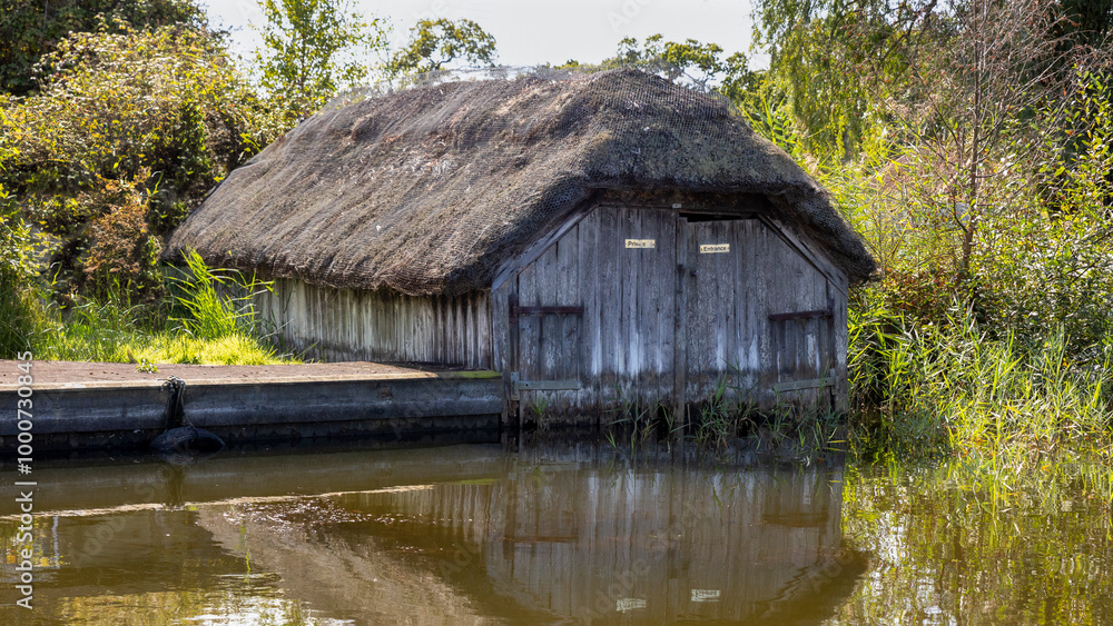 On the norfolk broads is an old thatched boat shed. It is located at Hickling, a village in Norfolk On the norfolk broads is an old thatched boat shed. It is located at Hickling, a village in Norfolk