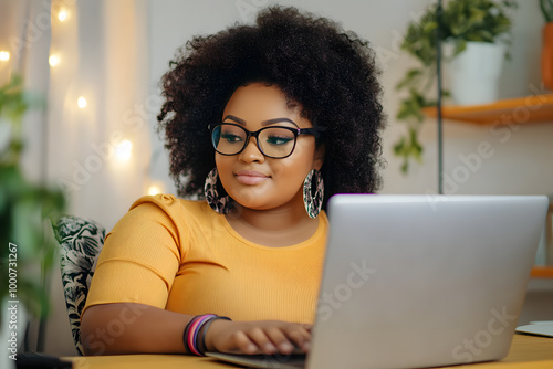 Attractive happy stylish plus size African black woman student afro hair in glasses studying online working on laptop computer at home office workspace. Diversity. Remote work, distance education