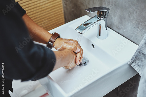 Washing hands, person and basin with liquid soap for bacteria, hygiene and germs. Above, bathroom and water with prevention for safety, protection and disinfection with dirt removal and self care photo