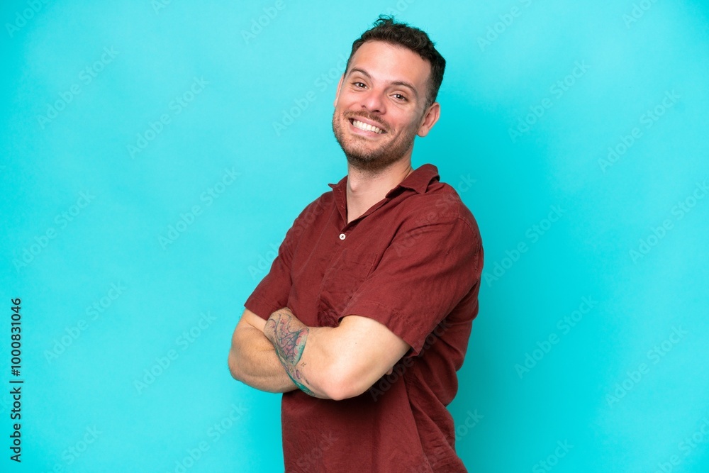 Young caucasian handsome man isolated on blue background with arms crossed and looking forward Young caucasian handsome man isolated on blue background with arms crossed and looking forward