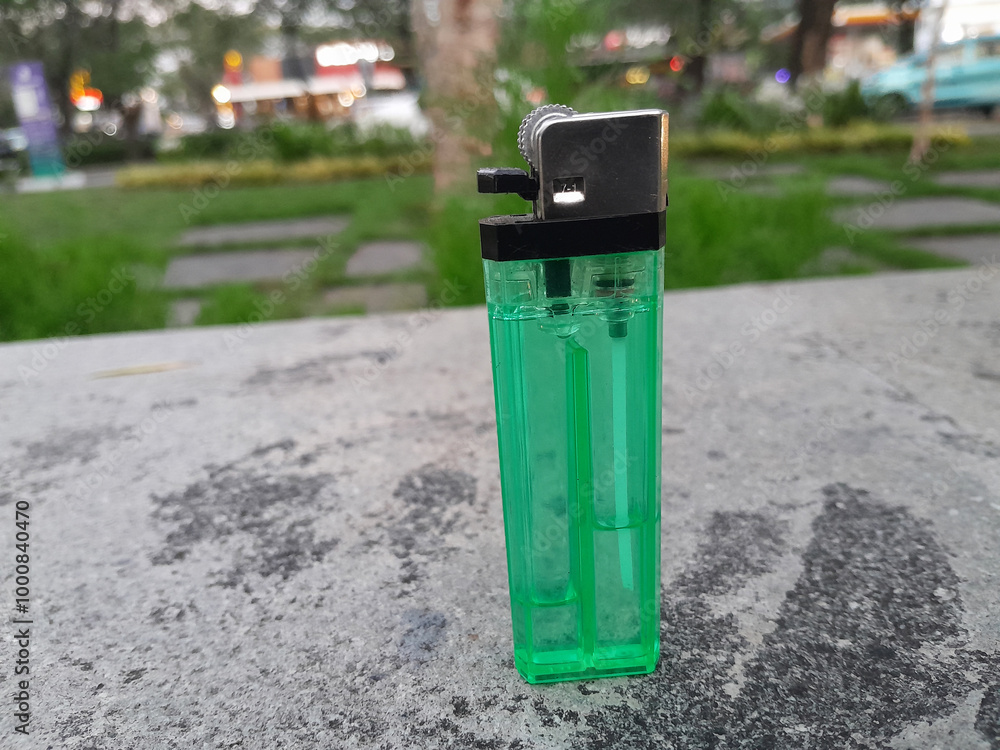 Green gas lighter on cement base Green gas lighter on cement base