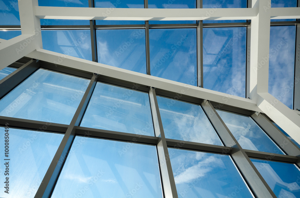Modern office building glass ceiling against blue skies Modern office building glass ceiling against blue skies