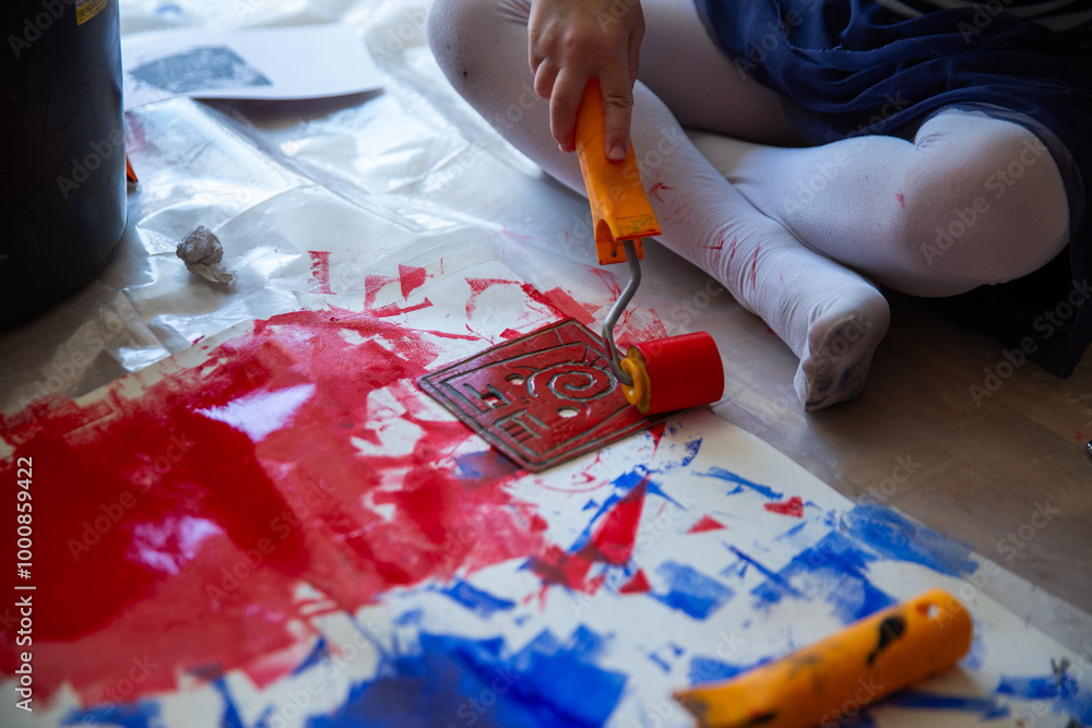 Obraz premium Children creating lino cut prints on paper using rollers, paint, and spoons in an art workshop. Creativity, craft techniques, and artistic expression, educational and creative stock imagery.