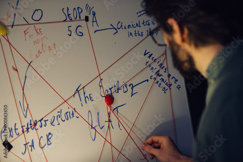 Принти на полотні A man is standing near a crazy table on a conspiracy theory board