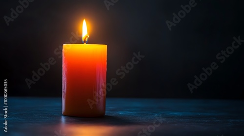 A single candle flame glows in the dark, creating a warm and inviting atmosphere.