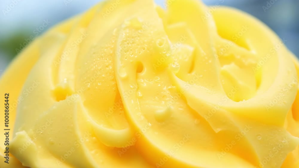 Close-up of swirled yellow butter with droplets on a smooth surface Close-up of swirled yellow butter with droplets on a smooth surface