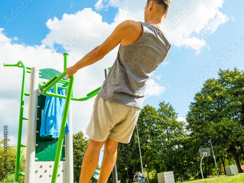 Man doing exercises on the public gym equipment. photo