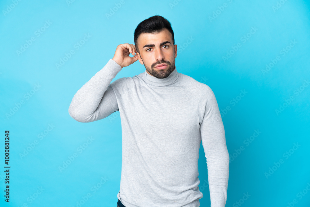 Caucasian man over isolated blue background having doubts Caucasian man over isolated blue background having doubts