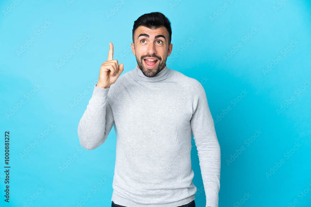 Caucasian man over isolated blue background intending to realizes the solution while lifting a finger up Caucasian man over isolated blue background intending to realizes the solution while lifting a finger up