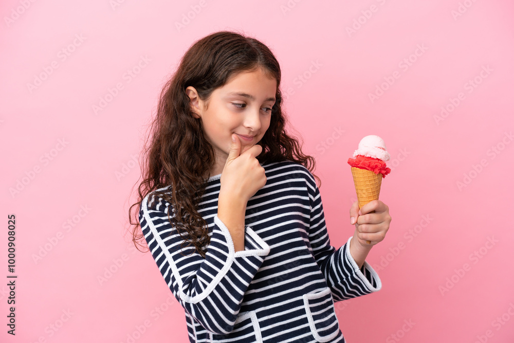 Little caucasian girl holding an ice cream isolated on pink background looking to the side and smiling Little caucasian girl holding an ice cream isolated on pink background looking to the side and smiling