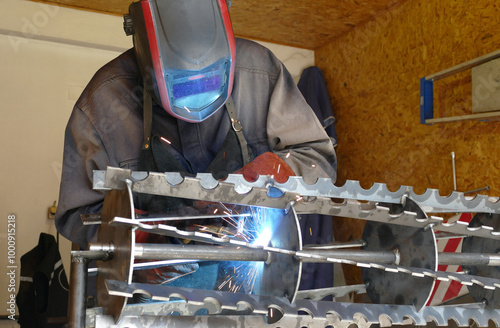 Welder Working in the Workshop; Welding of steel parts in the metal industry