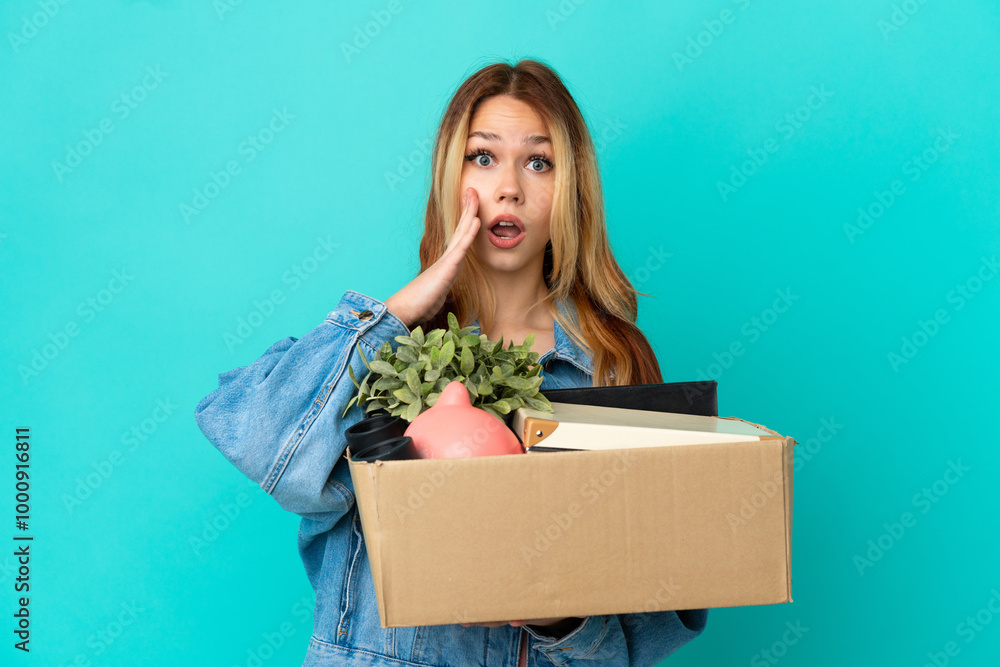 Teenager blonde girl making a move while picking up a box full of things with surprise and shocked facial expression Teenager blonde girl making a move while picking up a box full of things with surprise and shocked facial expression