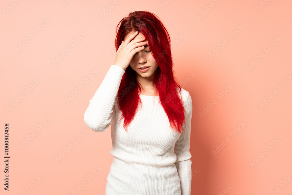 Teenager red hair girl isolated on pink background with headache Teenager red hair girl isolated on pink background with headache