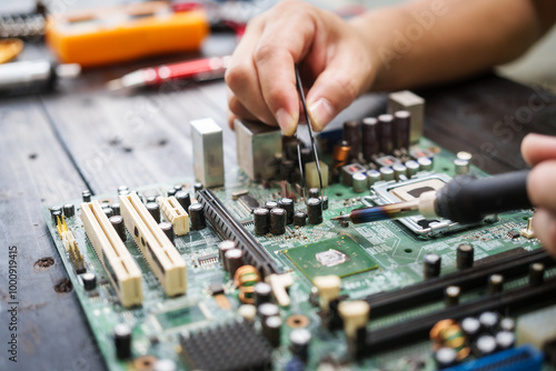 Photography Technician carefully repairs a computer circuit board, using precision tools to address hardware issues