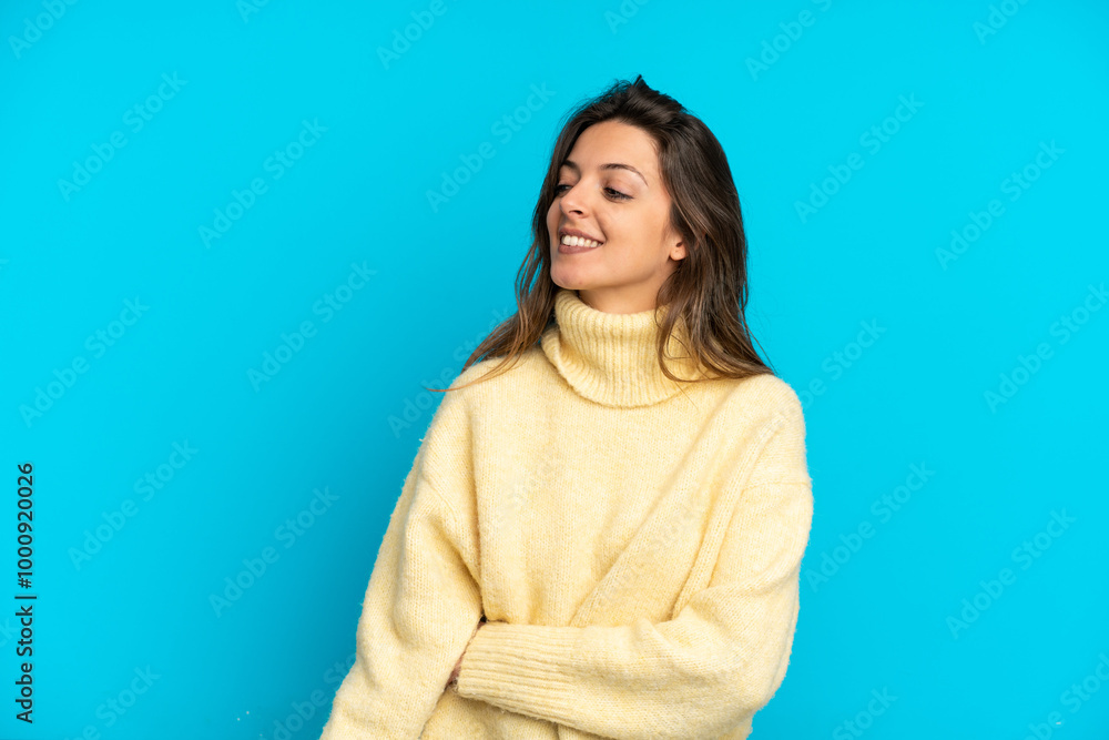 Young caucasian woman isolated on blue background looking to the side and smiling Young caucasian woman isolated on blue background looking to the side and smiling