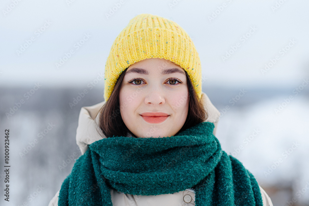 young beautiful slim asian girl standing outdoors in winter day smiling to camera, dressed in knitted yellow cap and green scarf, winter portrait young beautiful slim asian girl standing outdoors in winter day smiling to camera, dressed in knitted yellow cap and green scarf, winter portrait