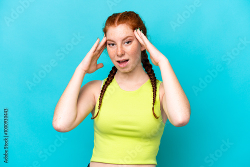 Young reddish woman isolated on blue background with surprise expression