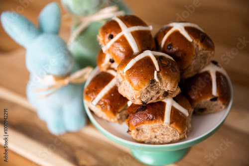 hot cross buns piled up with bunny decorations in the background photo