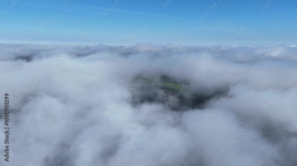 Aerial view of a forest landscape hidden beneath low clouds in Lithuania. Drone captures a misty forest landscape partially covered by low clouds on a clear day. Aerial view of a forest landscape hidden beneath low clouds in Lithuania. Drone captures a misty forest landscape partially covered by low clouds on a clear day.