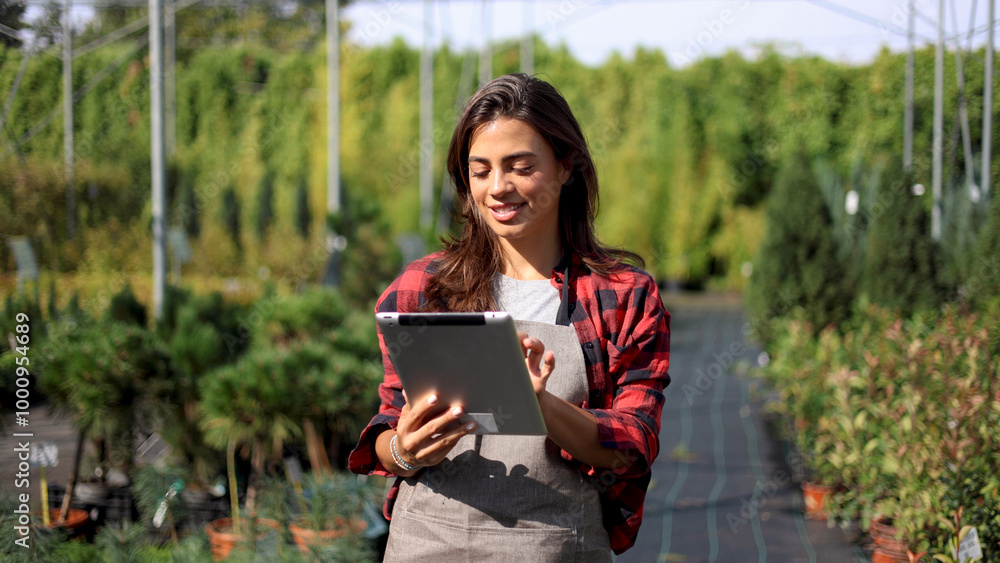 Female agricultural engineer using a digital tablet and planning planting at the garden center Female agricultural engineer using a digital tablet and planning planting at the garden center
