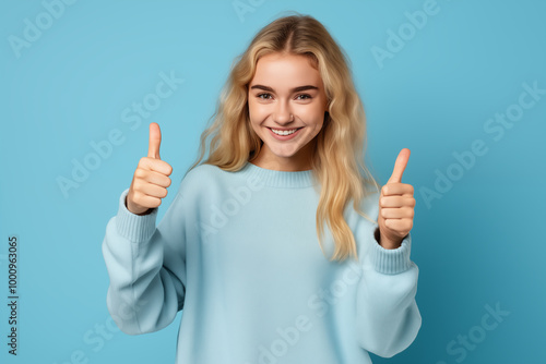 Young pretty blonde girl over isolated colorful background with thumb up