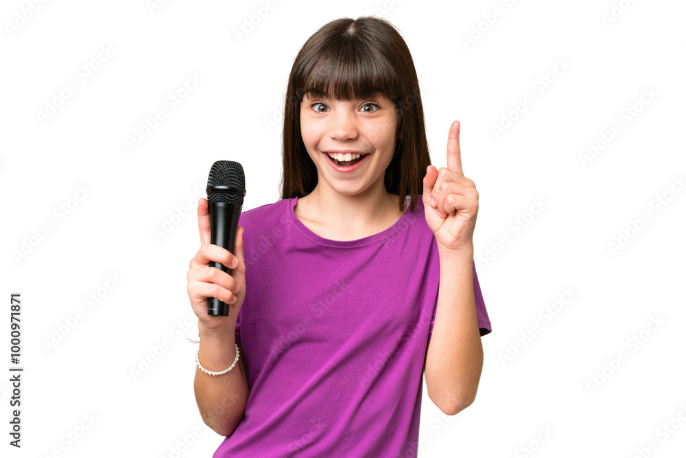 Little singer girl picking up a microphone over isolated background pointing up a great idea Little singer girl picking up a microphone over isolated background pointing up a great idea