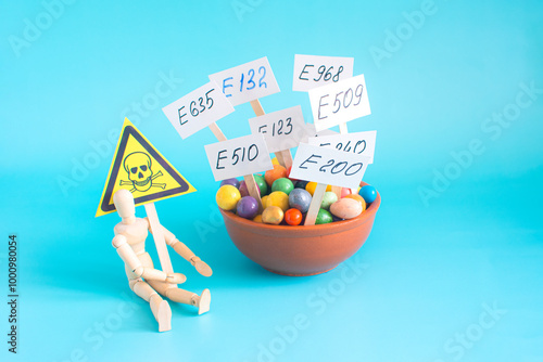 A cup with various food additives in close-up on a light background. Warning about the deadly dangers of uncontrolled use of dietary supplements