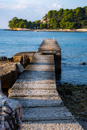 Fototapeta Naklejka Na Ścianę i Meble -  Bathing bay on the Mediterranean coast in Croatia. A long wooden bathing jetty with ladder into the sea.