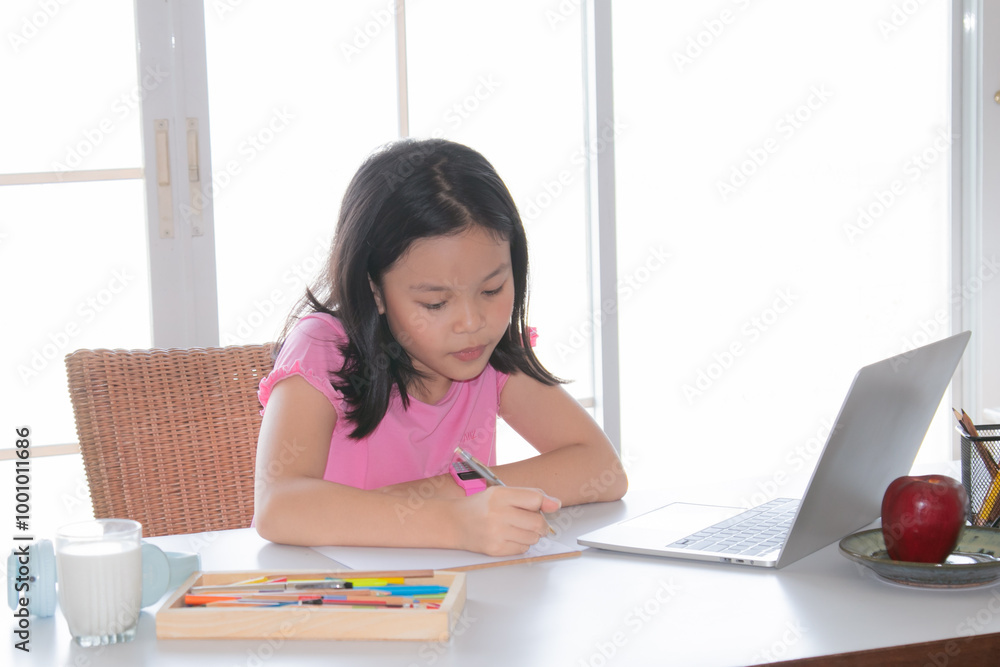 Adorable Asian girl happy learning online with technology laptop on desk at home, school girl typing answer or response with teacher study homeschool or learn from home, smart kids with technology Adorable Asian girl happy learning online with technology laptop on desk at home, school girl typing answer or response with teacher study homeschool or learn from home, smart kids with technology