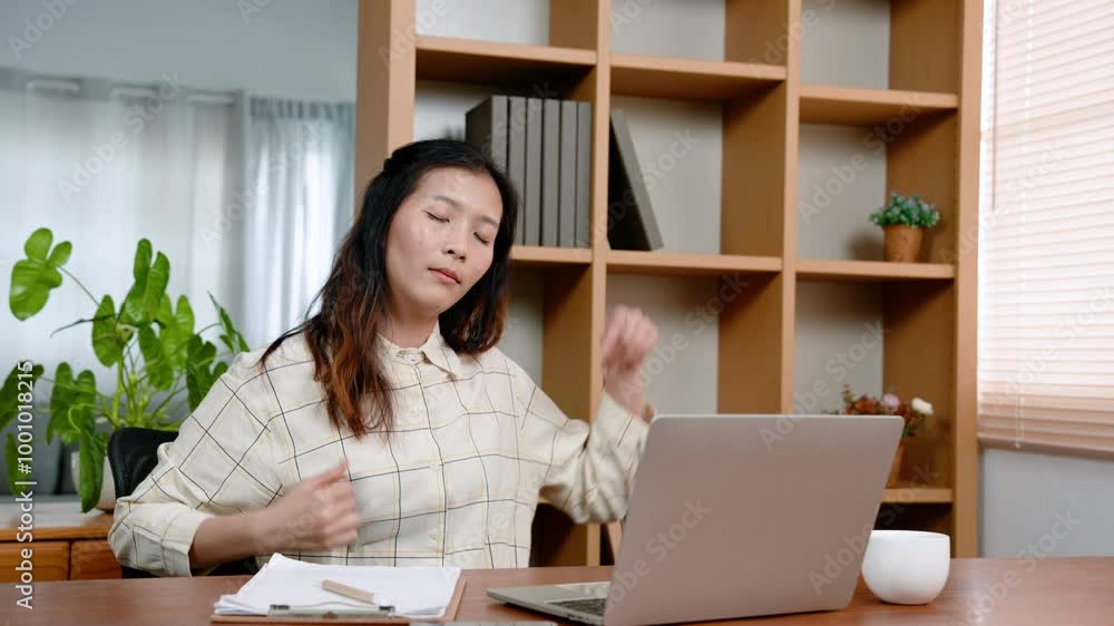 Young Asian female office worker sitting working on laptop computer, with shoulder pain neck stiffness, woman twisted body, pain office syndrome, which is common symptom among office workers. Young Asian female office worker sitting working on laptop computer, with shoulder pain neck stiffness, woman twisted body, pain office syndrome, which is common symptom among office workers.
