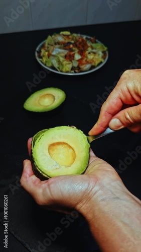 Scooping Avocado Flesh with a Spoon for Salad Preparation